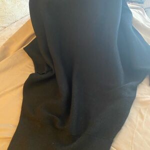 Black dress -looser on top and snug orotund the bottom.